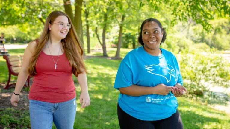 Two young women walking through a park.