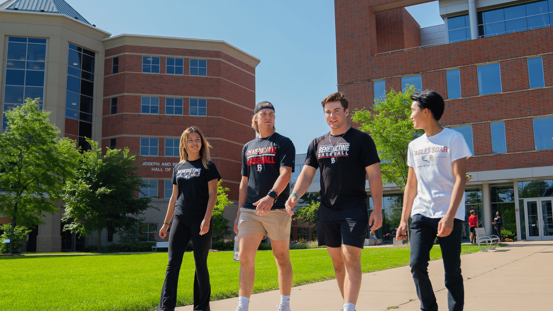 four undergraduates walking on quad