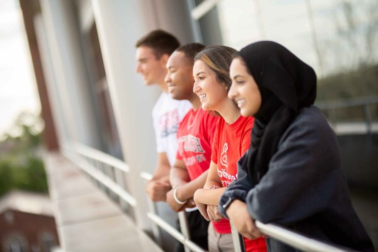 A group of people standing on a balcony.