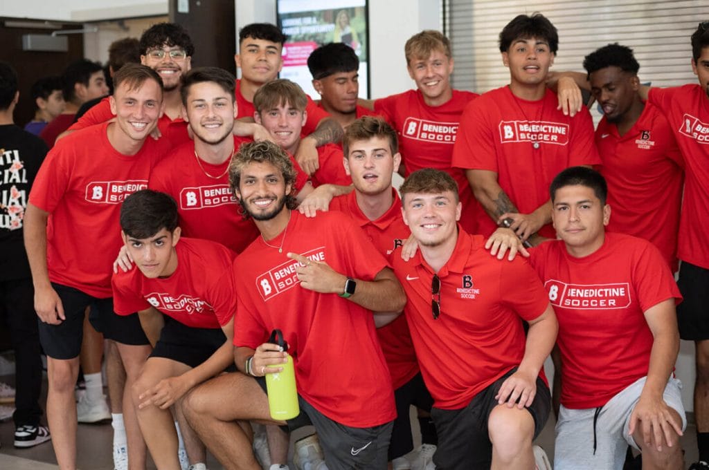 A group of young men in red shirts posing for a photo.