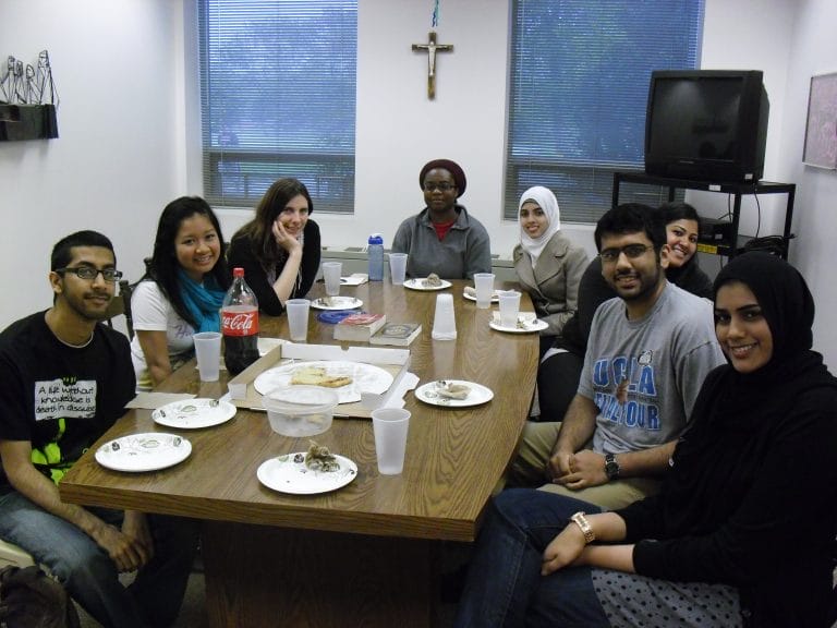 Campus Ministry student dialogue sitting around ministry table in lounge